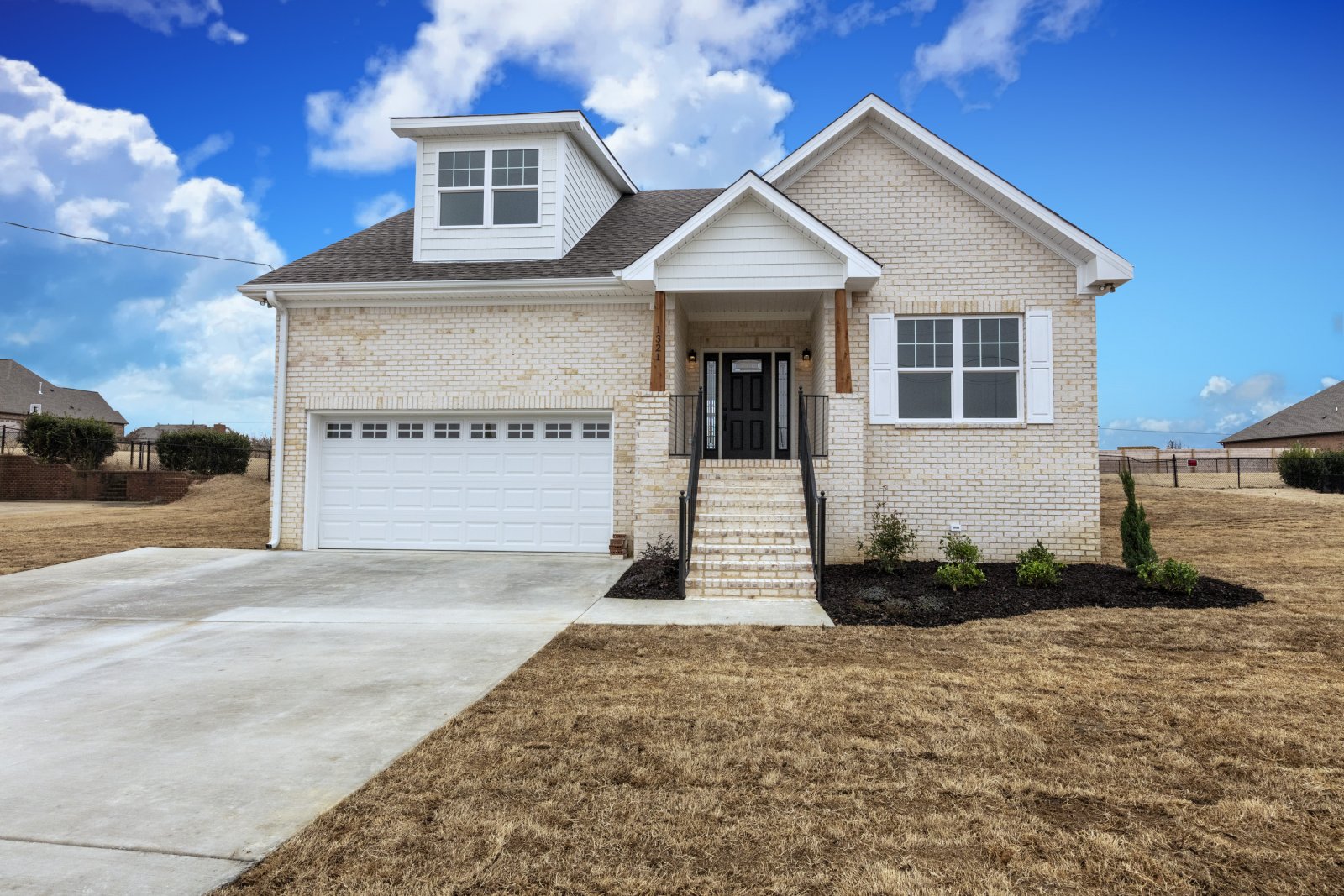 a large brick building with grass in front of a house